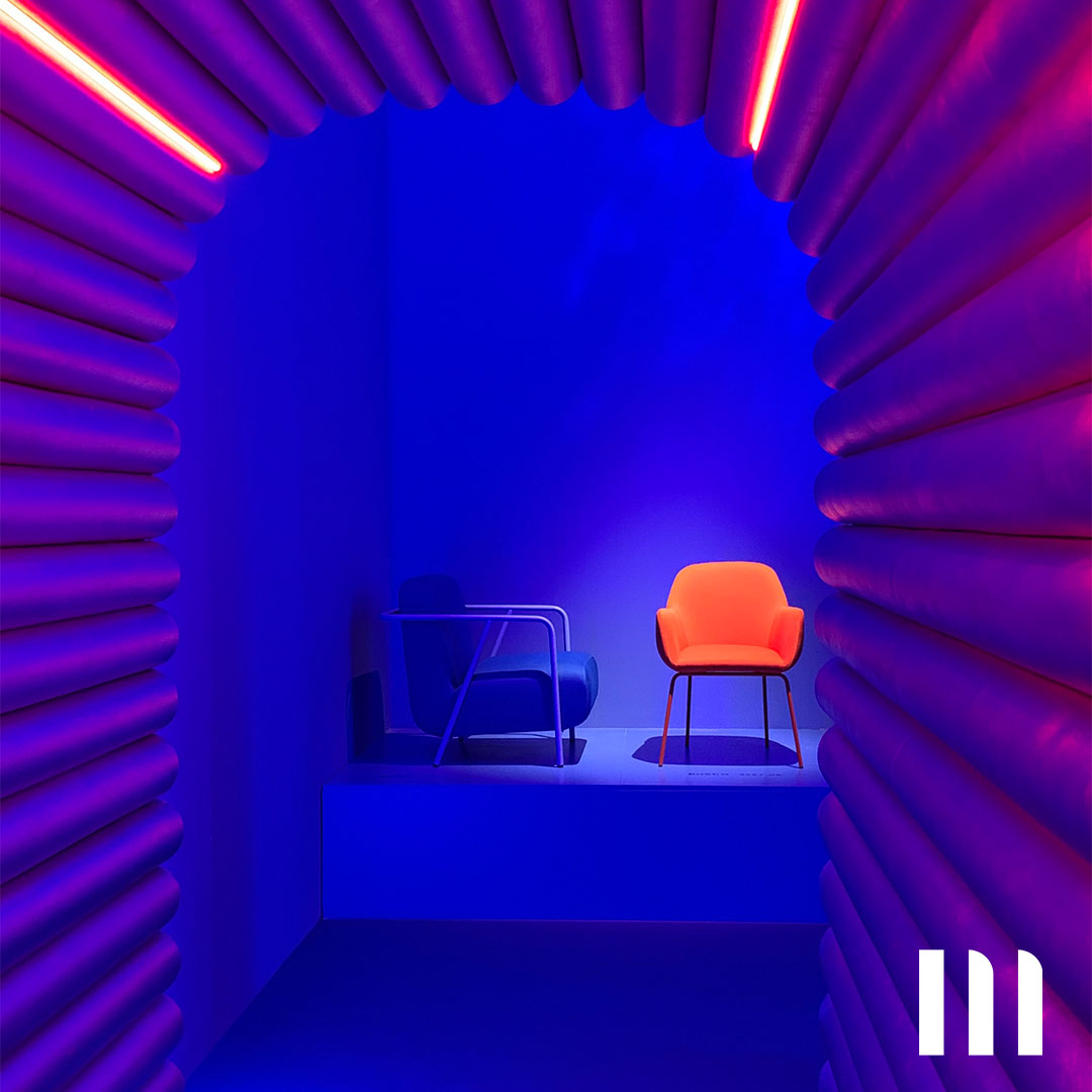 Zwei moderne Designerstühle inszeniert in einer futuristischen Lichtinstallation mit intensiver Neonbeleuchtung in Blau und Magenta.