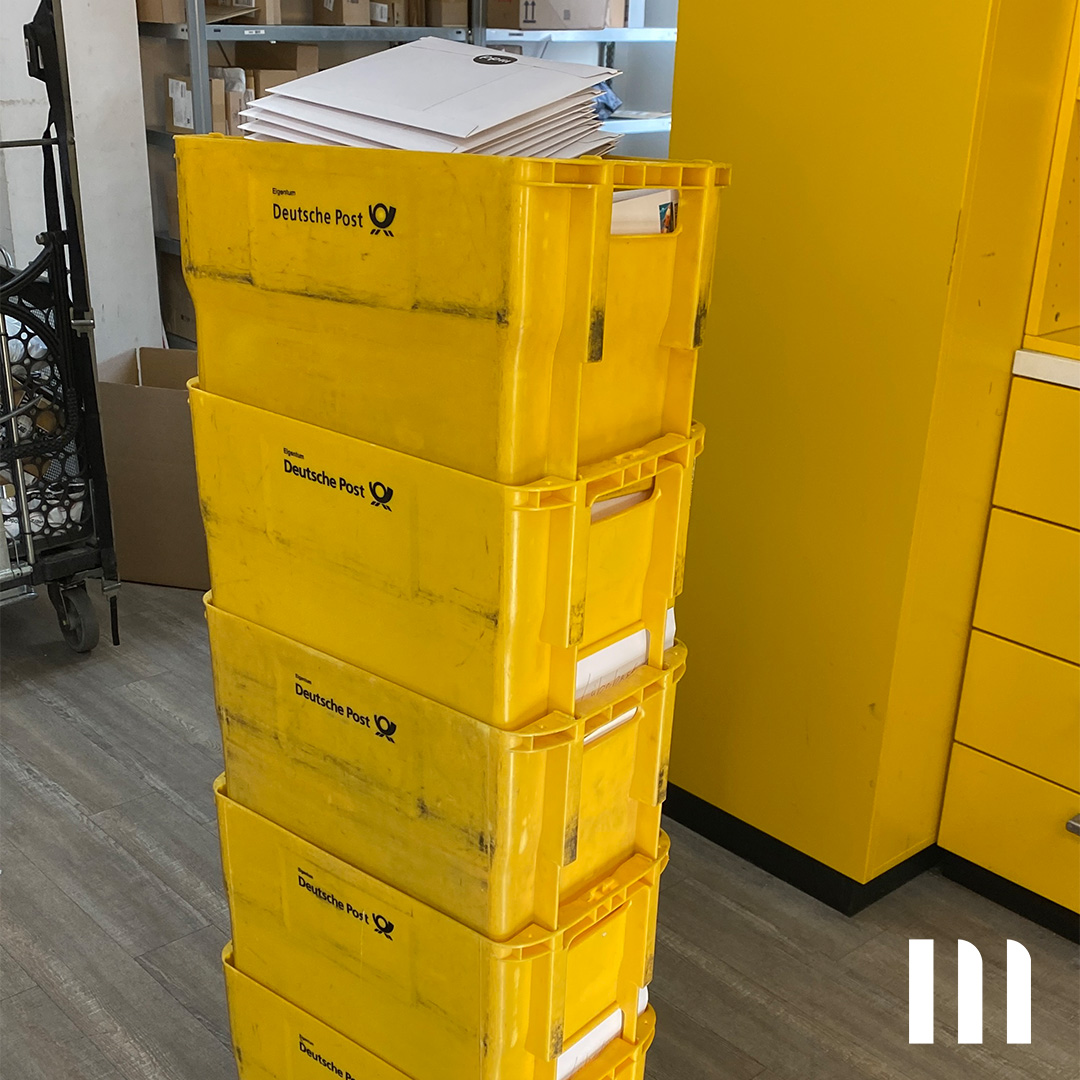 Gelbe Postbehälter der Deutschen Post voller nachhaltiger Geschenksets für Partner und Kund:innen.