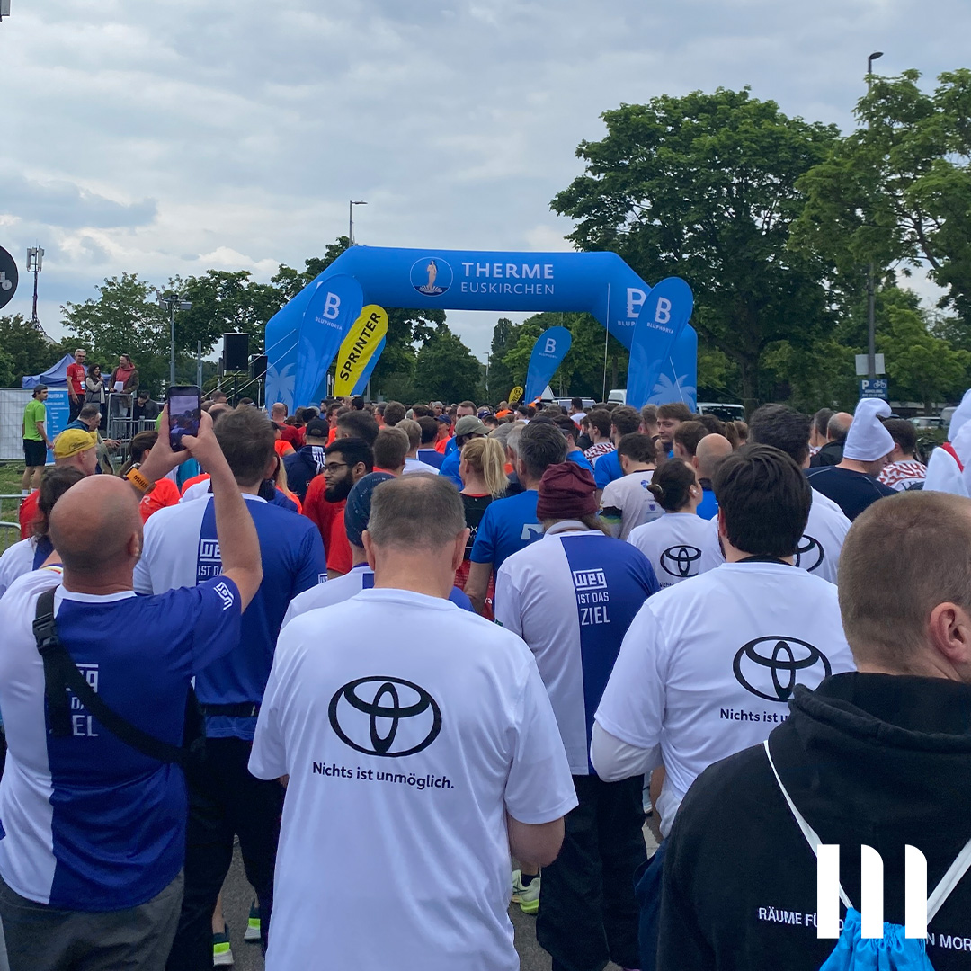 Teilnehmende im Startbereich des Firmenlauf Köln 2026 am Fühlinger See.